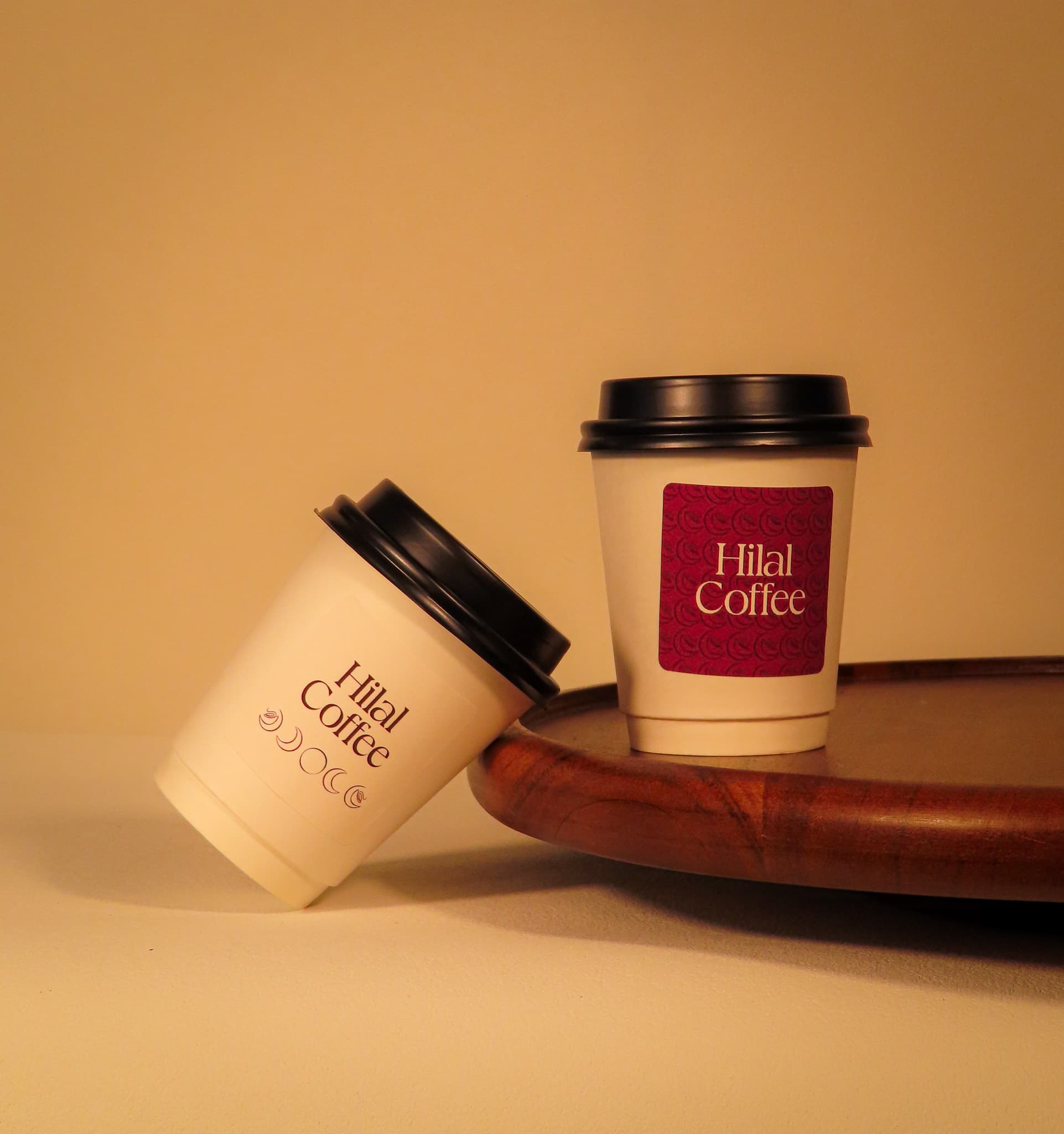 Two Hilal Coffee branded cups on a wooden serving tray