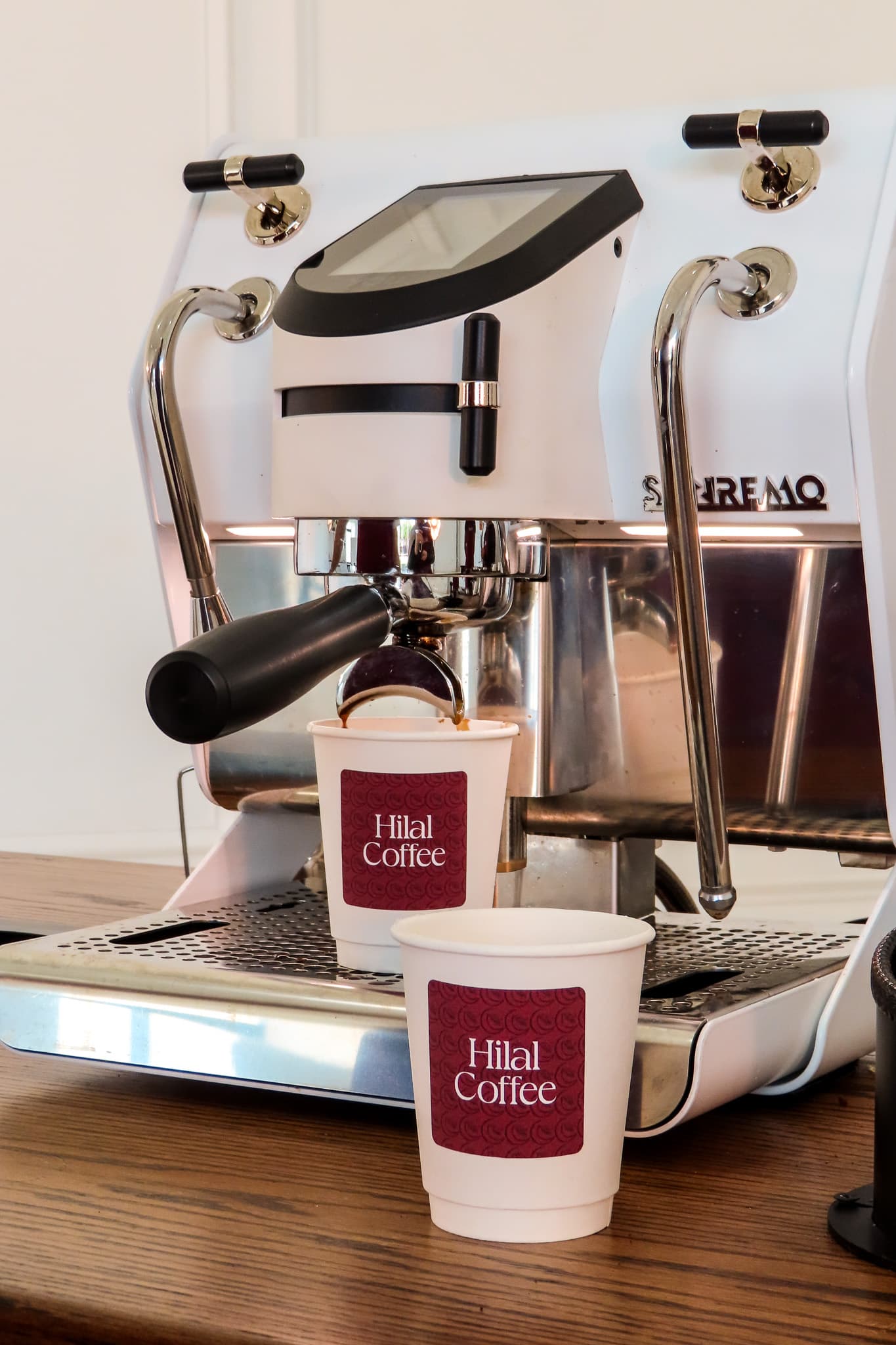 Espresso pouring into Hilal Coffee cups on the Sanremo machine