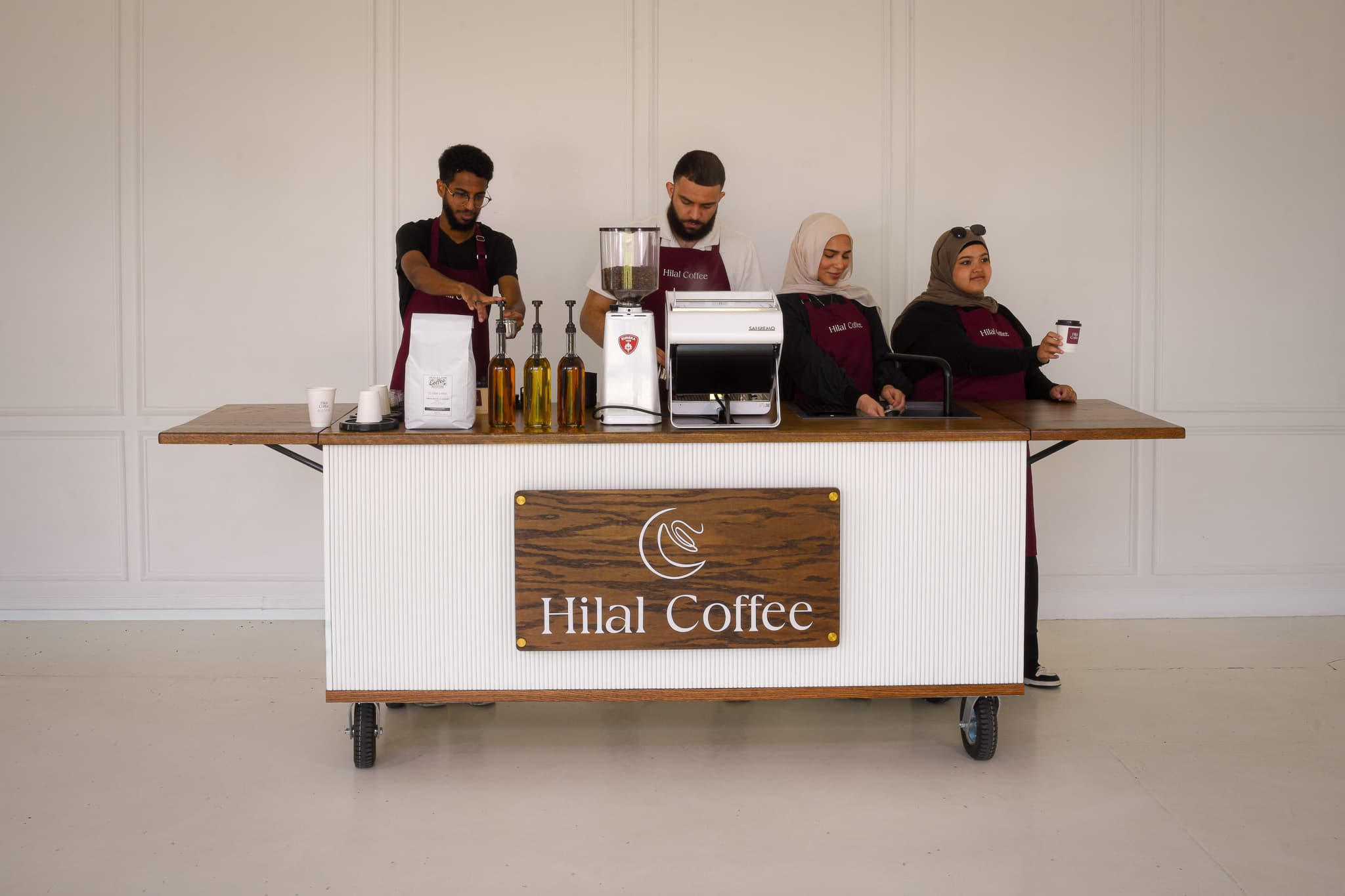 The Hilal Coffee barista team behind the styled mobile cart